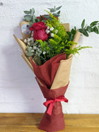 Single red rose in bouquet