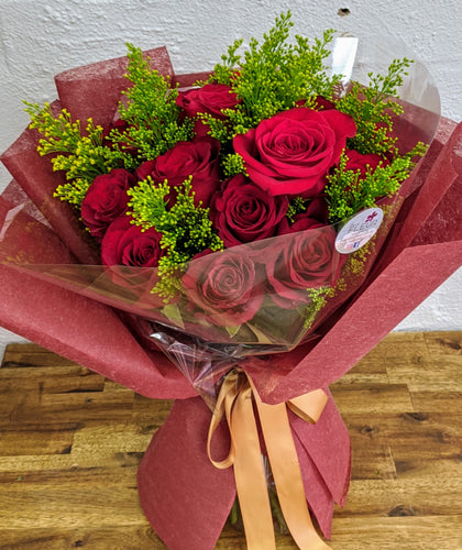 twenty red roses wrapped in bouquet with greenery