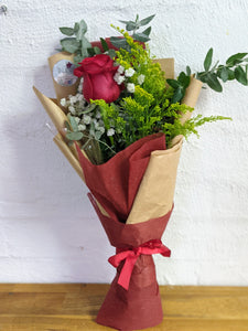 Single red rose in bouquet